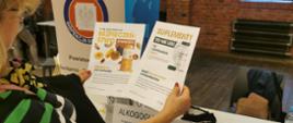 Kobieta trzyma w ręku ulotki informacyjne