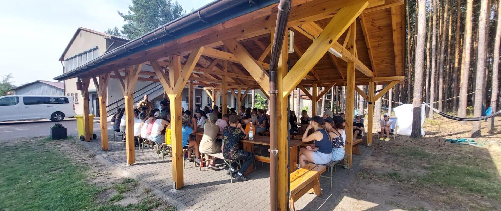 Zdjęcie przedstawia funkcjonariusza PSP oraz policji podczas pogadanki o bezpieczeństwie 