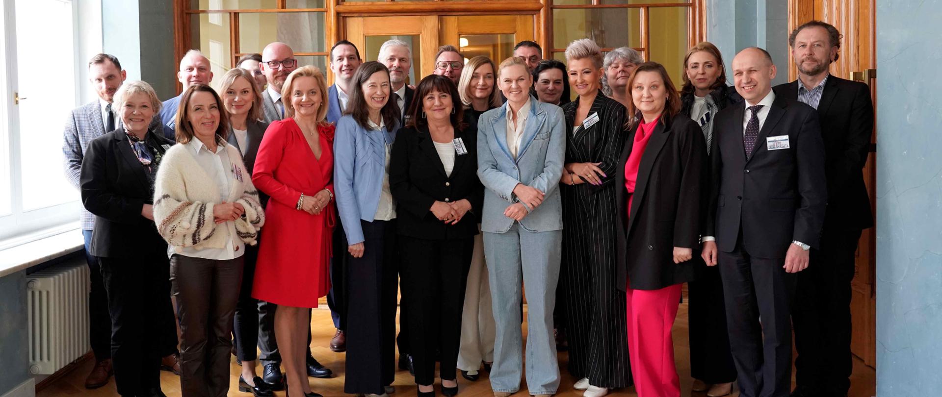 Zdjęcie zbiorowe, na korytarzu w gmachu ministerstwa stoją wszyscy kuratorzy, wśród nich minister Barbara Nowacka oraz kierownictwo MEN.