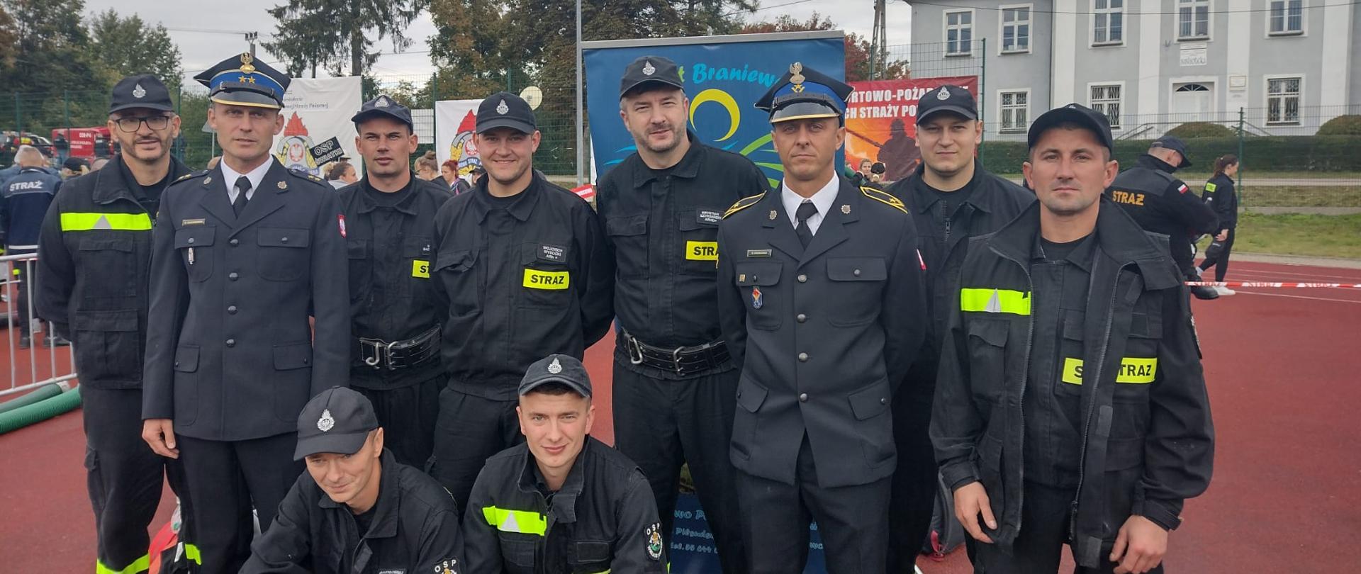Na zdjęciu grupa strażaków w mundurach uczestnicy zawodów, na boisku.