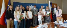 Uroczystość nadania polskiego obywatelstwa w Opolskim Urzędzie Wojewódzkim. Na zdjęciu widzimy Wicewojewodę Opolskiego Piotra Pośpiecha, Dyrektor Wydziału Spraw Obywatelskich i Cudzoziemców Annę Bartoszek-Dec oraz Zastępcę Dyrektora Wydziału Spraw Obywatelskich i Cudzoziemców Karolinę Superczyńską razem z nowymi obywatelami Polski w regionie. 
