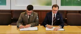 Sławomir Mazurek, wiceprezes NFOŚIGW i Jan Reklewski, dyrektor Świętokrzyskiego Parku Narodowego podpisują umowę o dofinansowanie budowy Centrum Edukacyjnego