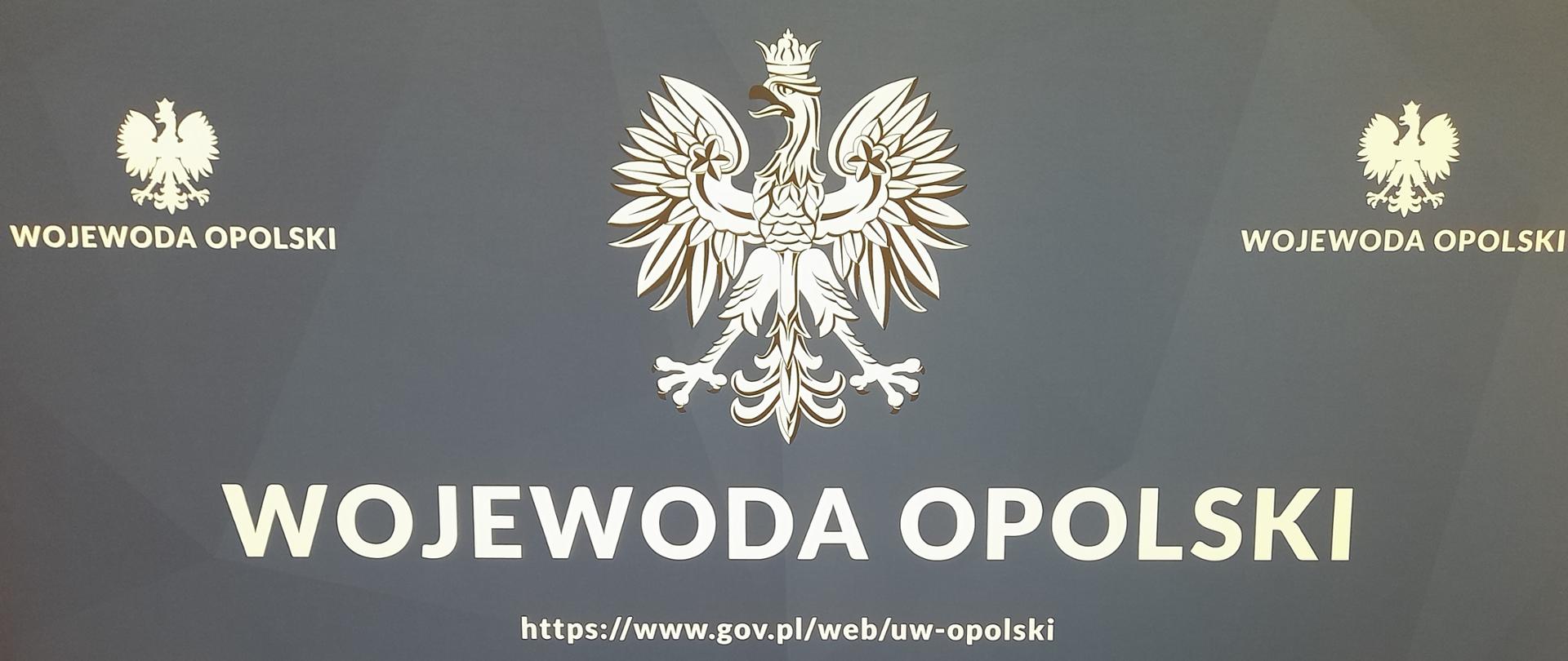 Niebieska plansza z godłem państwowym oraz napisem Wojewoda Opolski