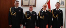 Czterech funkcjonariuszy PSP podczas ubranych w mundury strażackie 