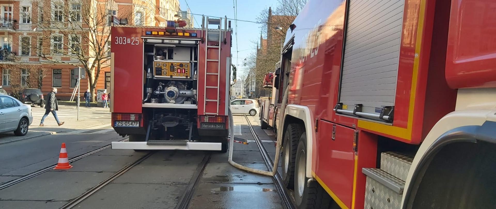 Na pierwszym planie ciężki samochód ratowniczo gaśniczy stojący przy zdarzeniu na ulicy Jagiellońskiej w Szczecinie