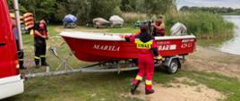 Na zdjęciu znajduje się łódź OSP Trzemeszno oraz trzech strażaków