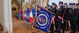 Zdjęcie przedstawia poczty sztandarowe Państwowej Straży Pożarnej i Ochotniczych Straży Pożarnych podczas Mszy Świętej w Bazylice Archikatedralnej pw. Świętego Jakuba Apostoła w Szczecinie dotyczącej poświęcenia kaplicy św. Floriana 