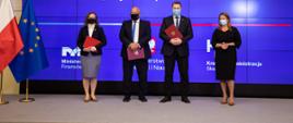 Minister Tadeusz Kościński, minister Przemysław Czarnek, minister Anna Chałupa i dyrektor Krajowej Szkoły Skarbowości Anna Orchowska po podpisaniu listu intencyjnego na tle baneru MF, MEN i KAS