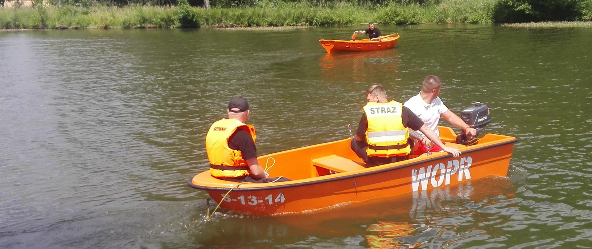 Na zdjęciu 2 łódki na akwenie wodnym, w jednej 2 strażaków i ratownik wodny w drugiej oddalonej od pierwszej 1 strażak