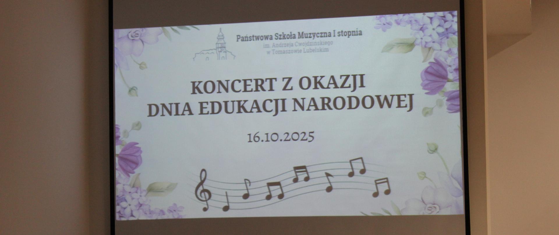 projektor z wyświetlanym plakatem z okazji Dnia Edukacji Narodowej, posiada kolorowe kwiatki, nuty na pięciolinii z kluczem wiolinowym oraz napisy