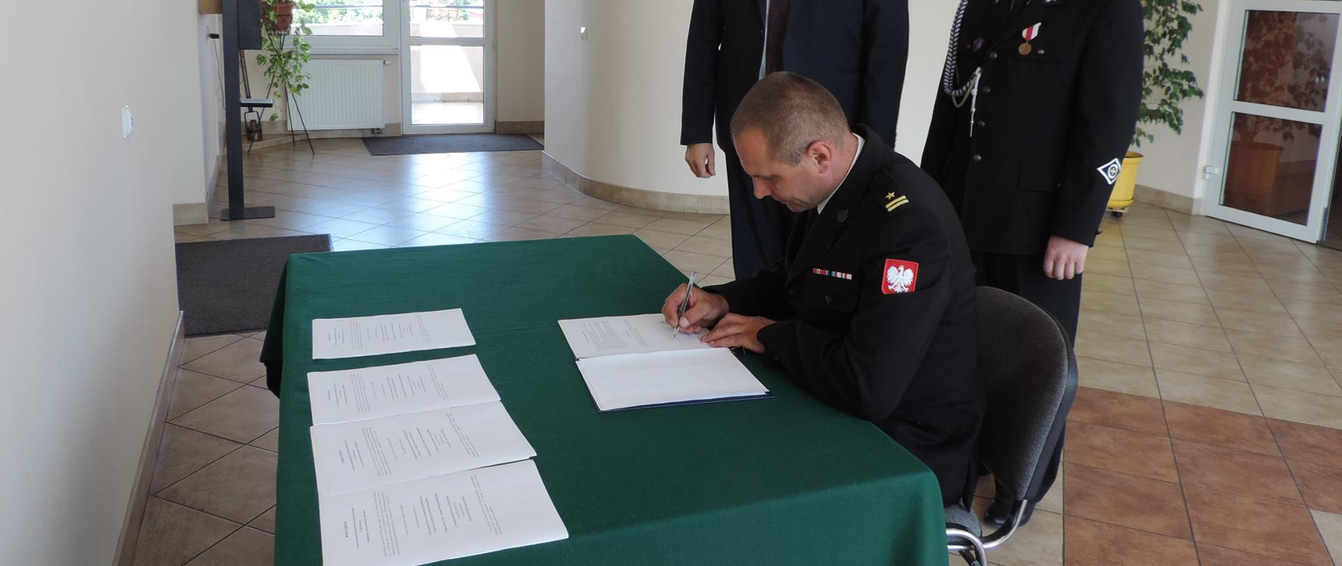 Zdjęcie przedstawia Komendanta KP PSP Opatów podpisującego porozumienie dot. włączenia OSP Czekarzewice II w struktury KSRG