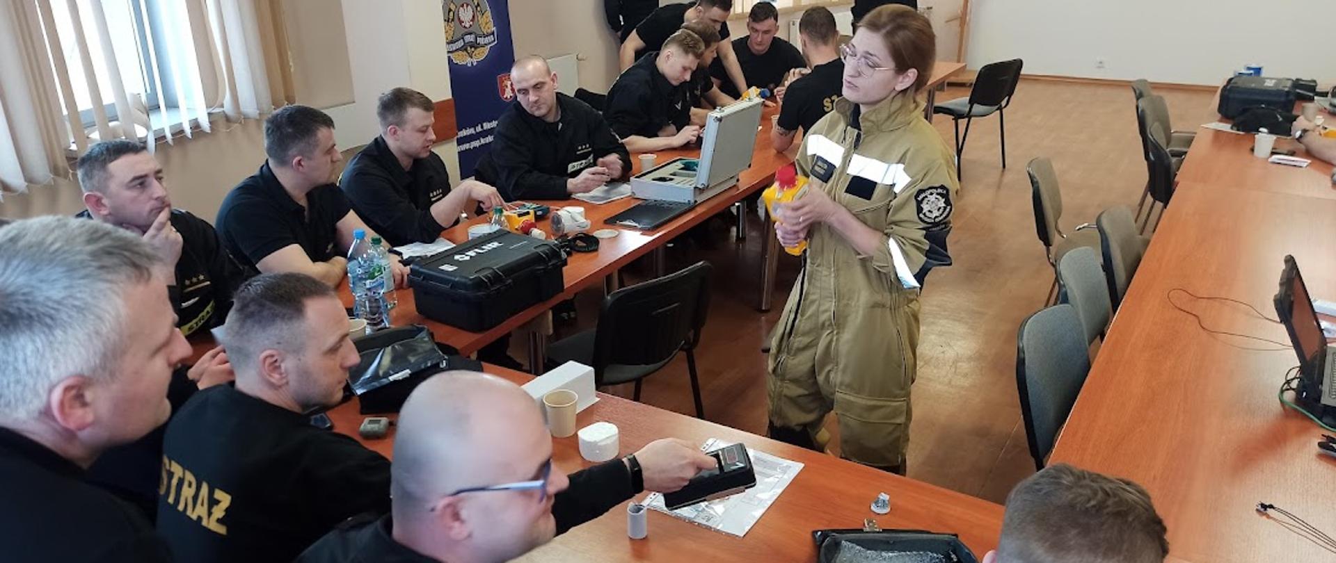 Na pierwszym planie widać wykładowcę oraz uczestników szkolenia z zakresu radiologii 