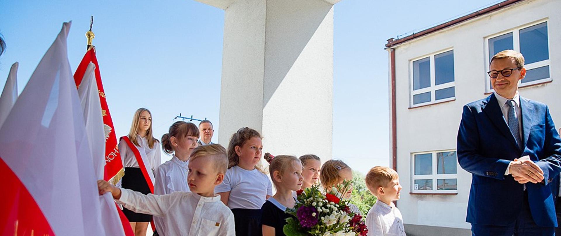 Premier patrzy na uczniów.