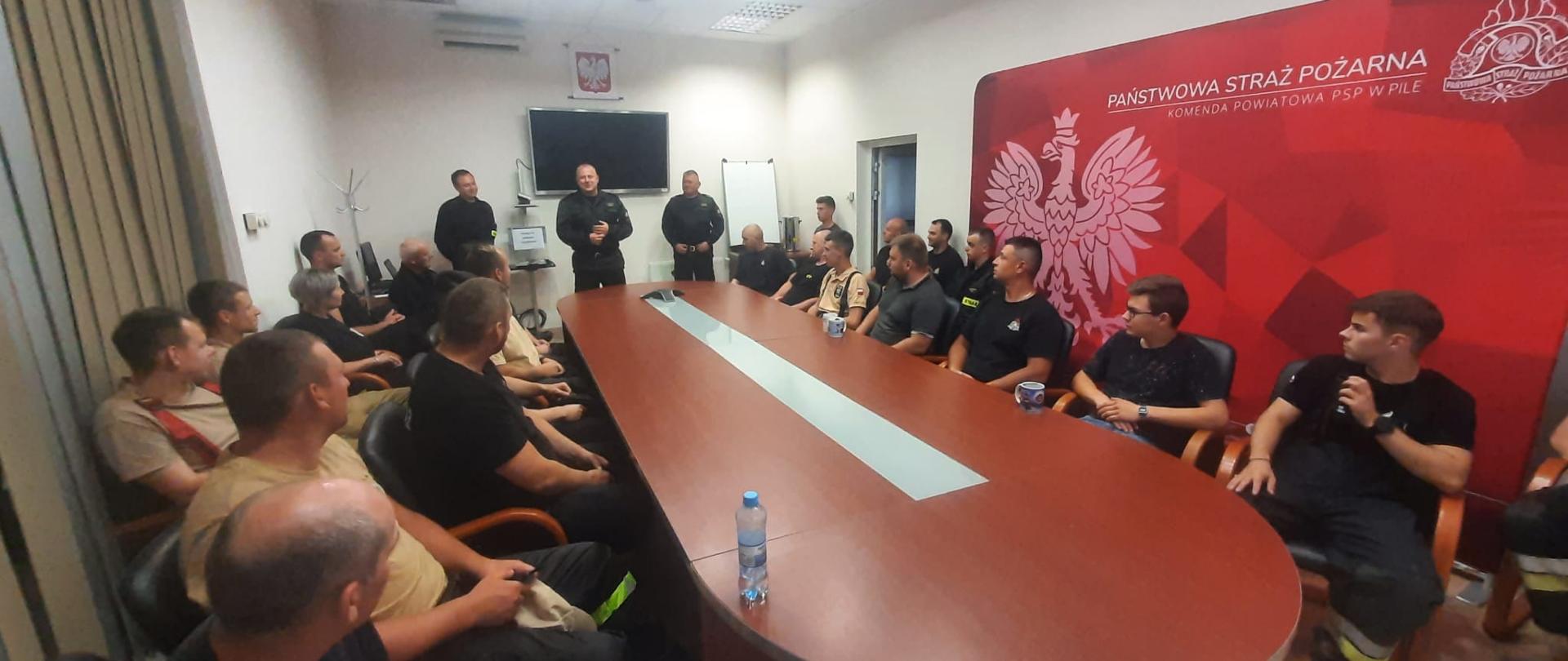 Na zdjęciu widać strażaków oraz Komendanta Powiatowego na szkoleniu przed ćwiczeniami odbywającym się w KP PSP Piła.
