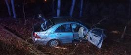 Widać uszkodzony samochód od strony pasażera, jest noc