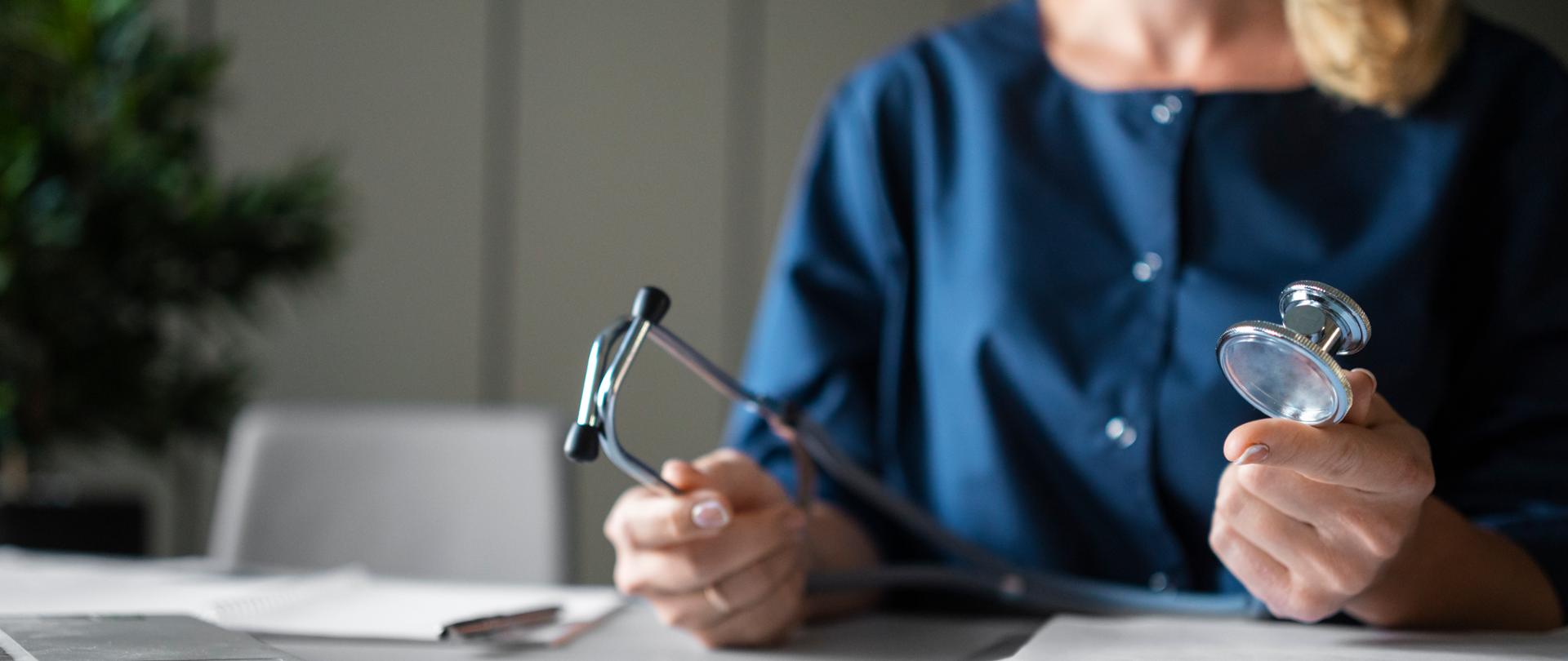 lekarka trzyma w dłoniach stetoskop