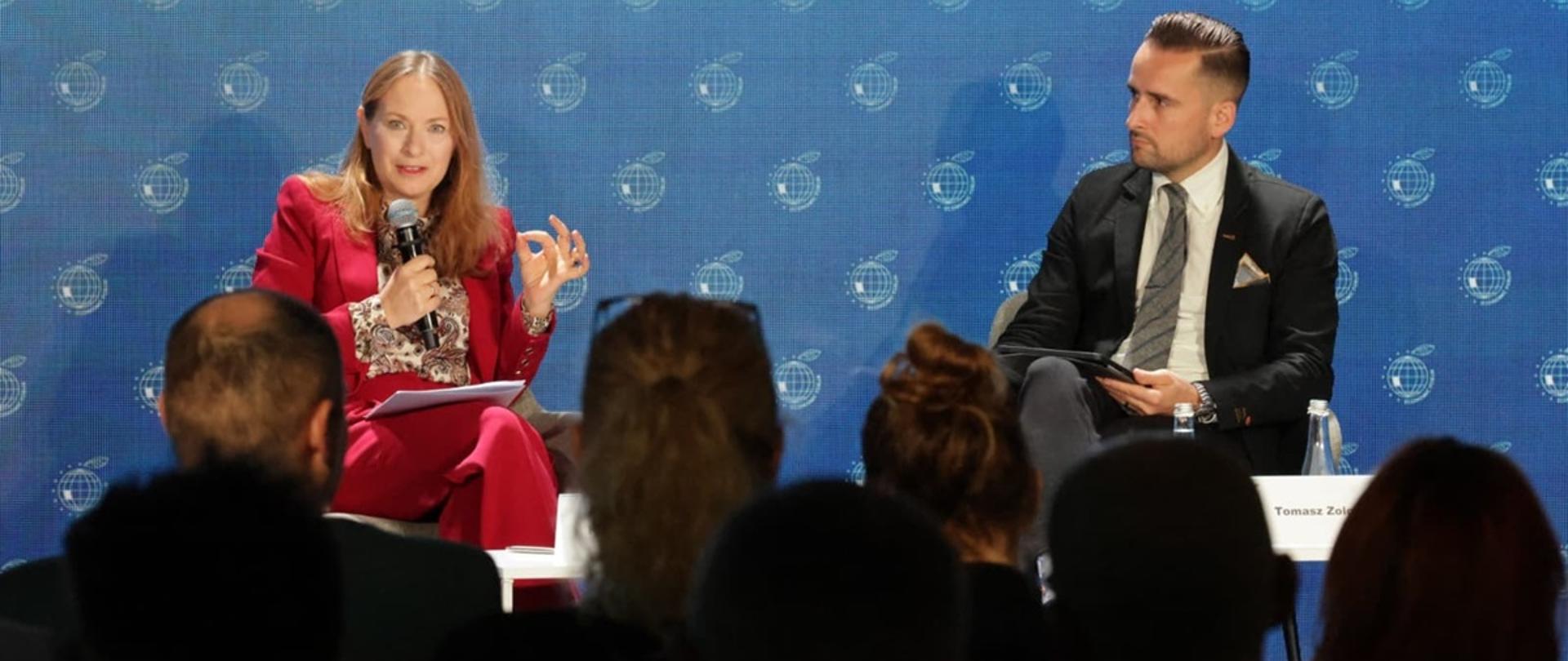 Minister funduszy i polityki regionalnej Katarzyna Pełczyńska-Nałęcz siedzi w fotelu i przemawia do mikrofonu, po jej lewej stronie siedzi red. money.pl Tomasz Żółciak
