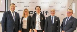Pod ścianką z napisami PPNT stoi minister Czarnek, dwie kobiety w białych bluzkach i czarnych marynarkach, i dwóch mężczyzn w garniturach.