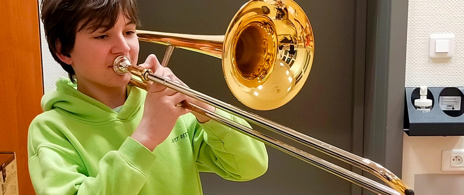 Grafika przedstawia ucznia PSM I st. grającego na puzonie