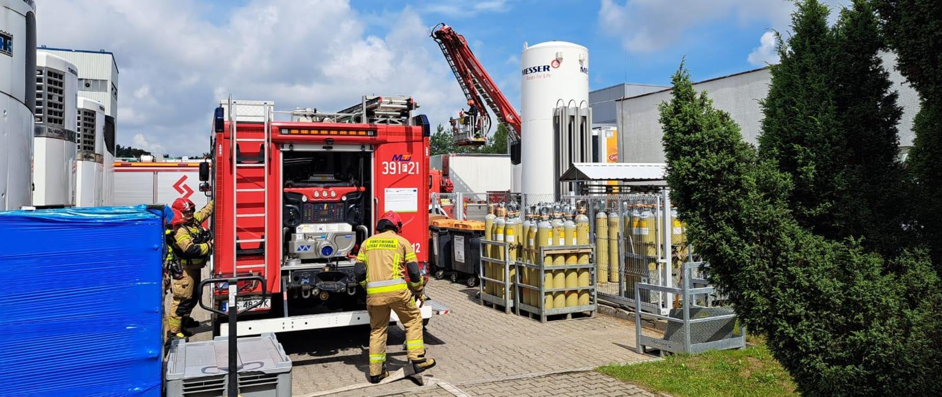 Strażacy przygotowują się do ćwiczeń przy samochodzie 