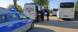 Kontrola autobusu szkolnego przed jedną ze szkół podstawowych w powiecie mińskim. Funkcjonariusze mazowieckiej Inspekcji Transportu Drogowego przekazują kierowcę do dalszych czynności służbowych patrolowi Policji.
