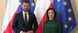 Minister Kamil Bortniczuk spotkał się z Ambasador Azerbejdżanu Nargiz Gurbanovą. Minister i pani ambasador stoją na pierwszym planie, w tle flaga polski i Unii Europejskiej