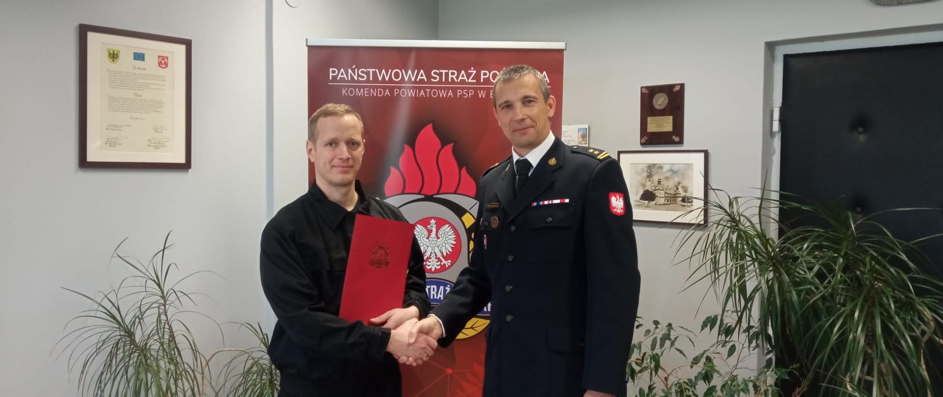 Awans na wyższe stanowisko służbowe - zdjęcie przedstawia Komendanta Powiatowego PSP w Brzegu oraz awansowanego strażaka.