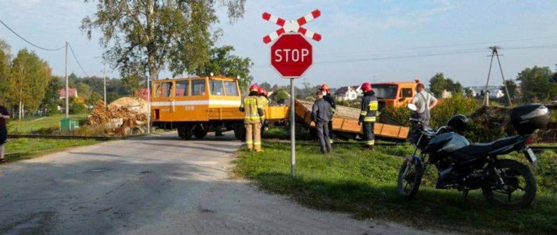 Zdjęcie przedstawia wykolejoną drezynę na przejeździe kolejowym