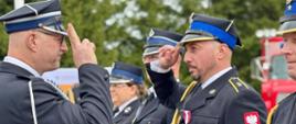mężczyzna w mundurze, wojewoda, salutuje mężczyźnie w mundurze