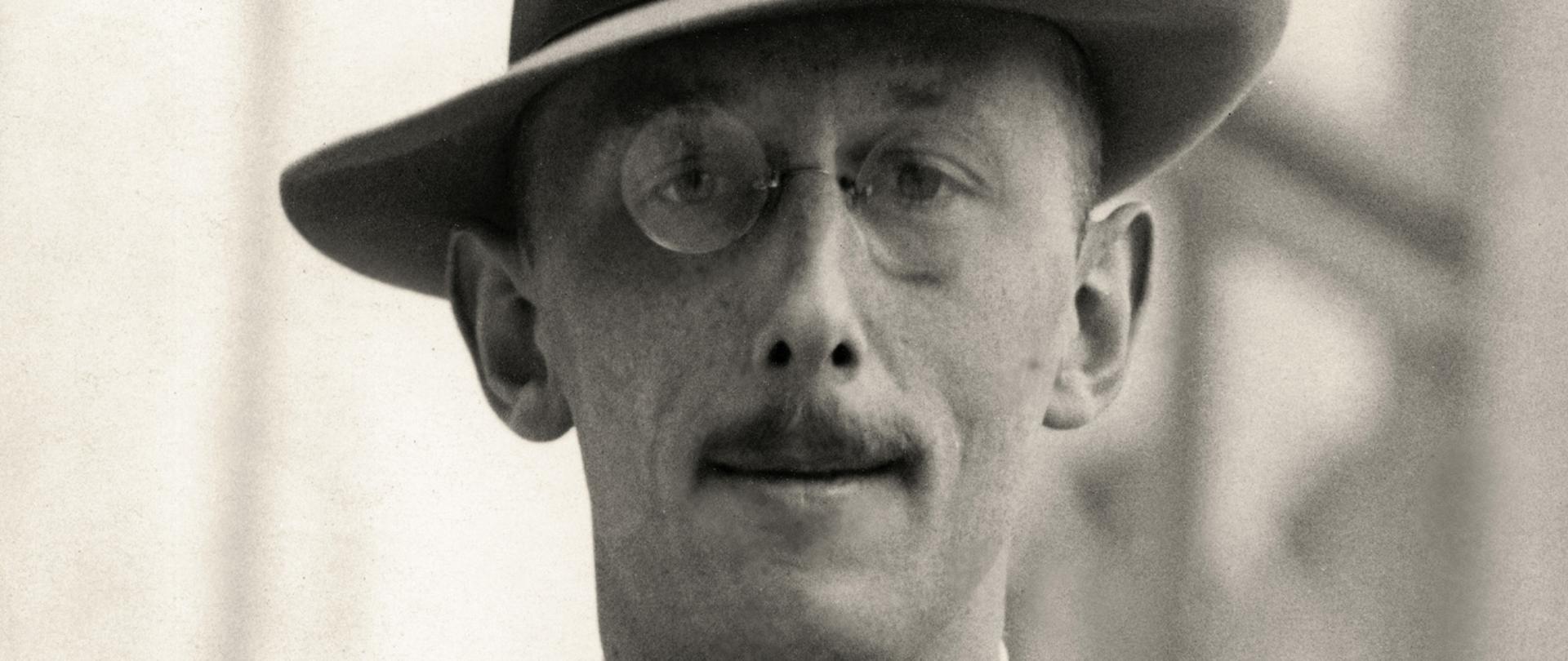 Kajetan Dzierżykraj-Morawski - portret mężczyzny w okrągłych okularach i szarym kapeluszu. Wąsy, muszka ciemna marynarka, kamizelka i biała koszula.