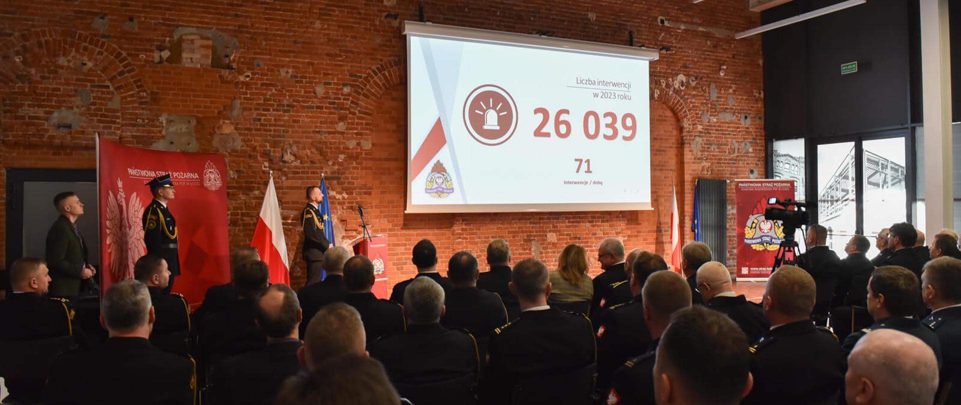 uczestniczy narady w trakcie oglądania filmu, który wyświetlony jest na ekranie rzutnika