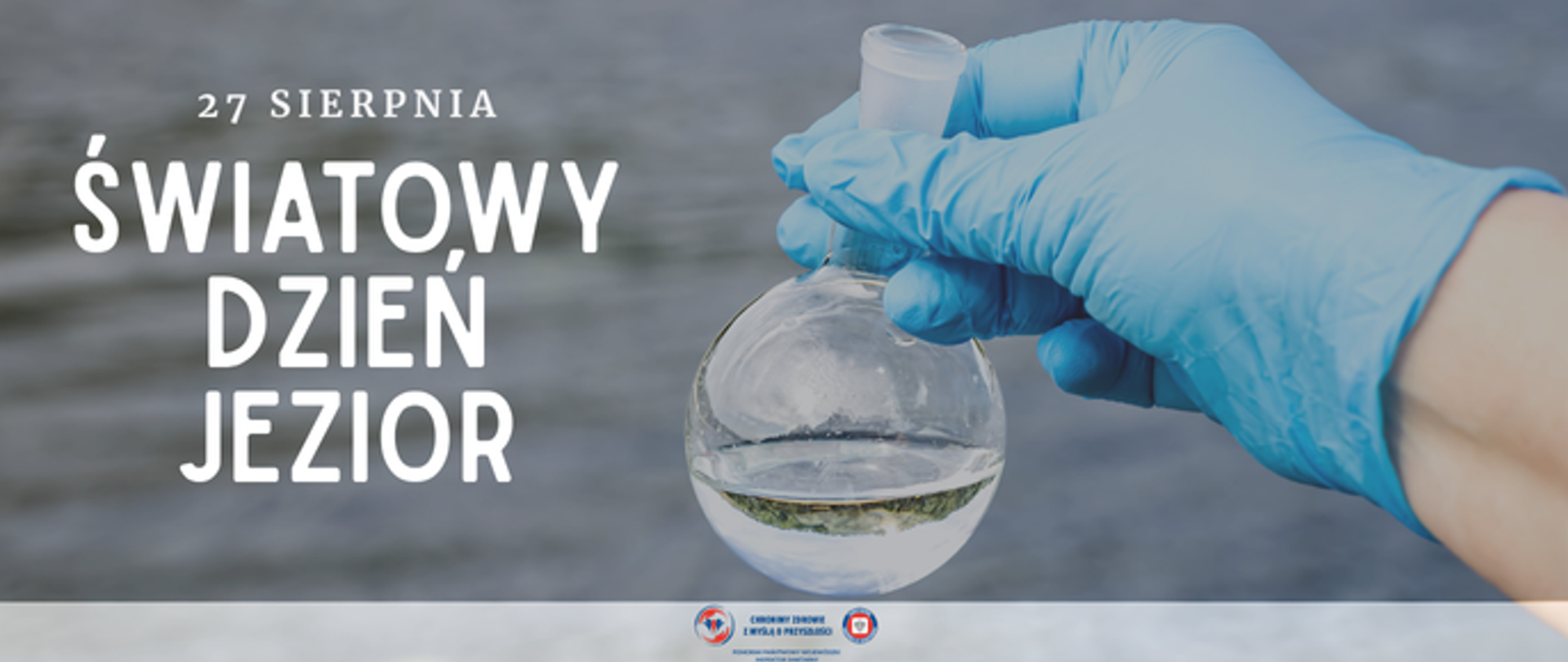Grafika z okazji Światowego Dnia Jezior. Po prawej dłoń w niebieskiej rękawiczce laboratoryjnej trzyma szklaną kolbę z próbką wody. Po lewej napis: „27 sierpnia – Światowy Dzień Jezior”. W tle rozmyta tafla wody.