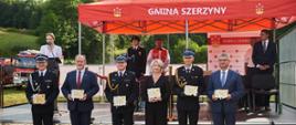 Na zdjęciu widać stojących od lewej:
Wójt Gminy Szerzyny Grzegorz Gotfryd, Prezes Zarządu Wojewódzkiego Funduszu Ochrony Środowiska i Gospodarki Wodnej w Krakowie Kazimierz Koprowski, Komendant Miejski PSP w Tarnowie st. bryg. Krzysztof Gładysz, radna gminy Szerzyny Elżbieta Pancerz , zastępca Małopolskiego Komendanta Wojewódzkiego PSP bryg. Przemysław Przęczek, Poseł na Sejm RP Wiesław Krajewski.
Stojący trzymają w ręku wyróżnienia.
