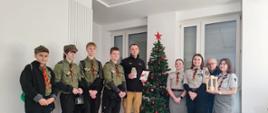 Na zdjęciu widoczny Komendant Powiatowy Państwowej Straży Pożarnej w Oleśnie – bryg. Andrzej Wróbel wraz z harcerzami, którzy przekazali Betlejemskie Światełko Pokoju. Zdjęcie wykonane w sali konferencyjnej komendy na tle świątecznej choinki.