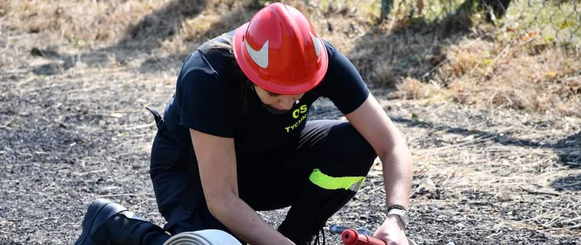 Zawodniczka podczas podłączania węża do rozdzielacza