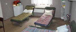 Miejsca noclegowe w siedzibie OSP. W salce szkoleniowej znajdują się 3 łózka polowe. Na nich leżą śpiwory i poduszki. W pomieszczeniu stoi też lodówka, a na niej leży torba medyczna.