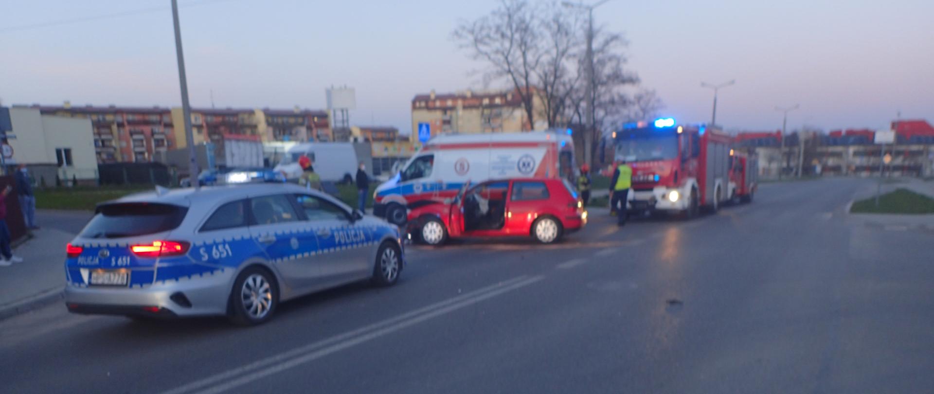 Widoczny samochód biorący udział w zdarzeniu oraz samochody służ ratowniczych.