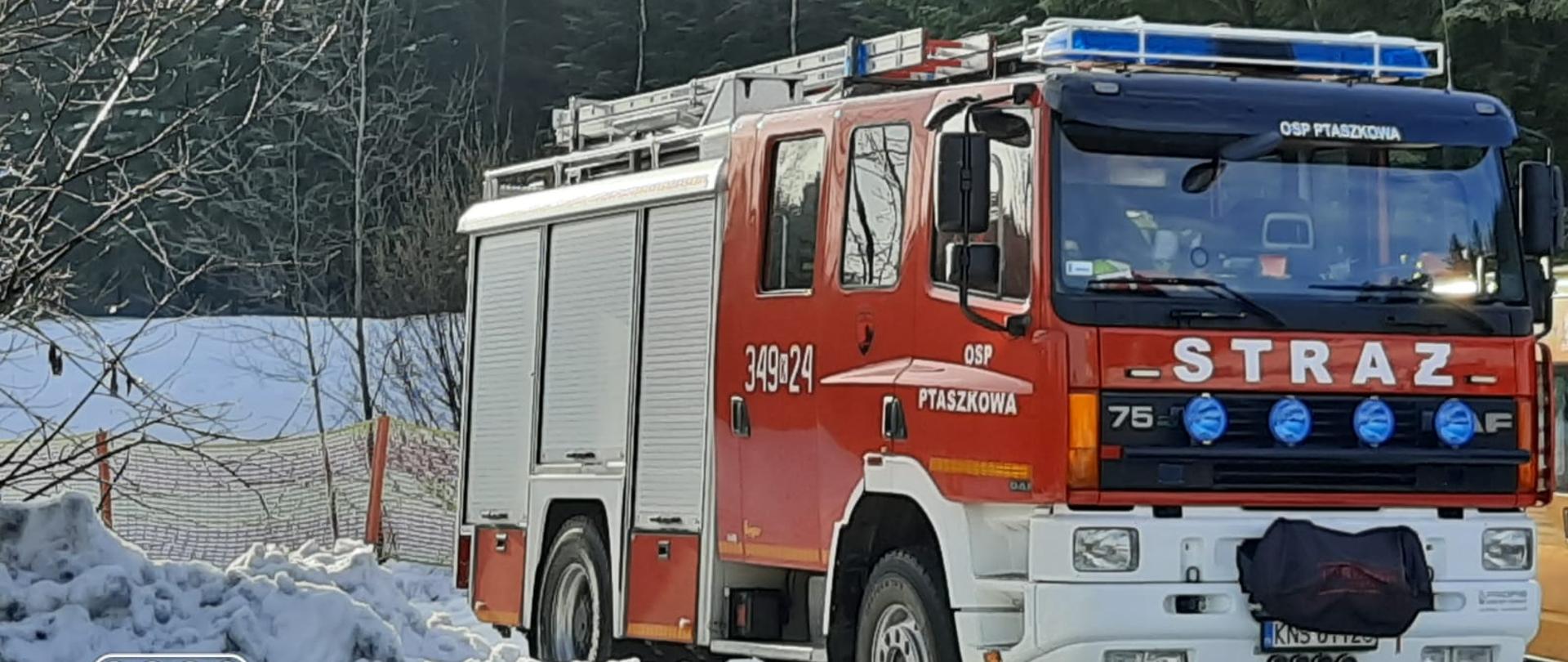 Samochód ratowniczo-gaśnczy OSP Ptaszkowa na zabezpieczeniu zawodów. Obok zwały śniegu.