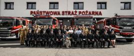 Zdjęcie grupowe pracowników i funkcjonariuszy komendy powiatowej straży pożarnej na tle budynku komendy