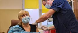pielęgniarz i kobieta szczepiona przeciw COVID-19