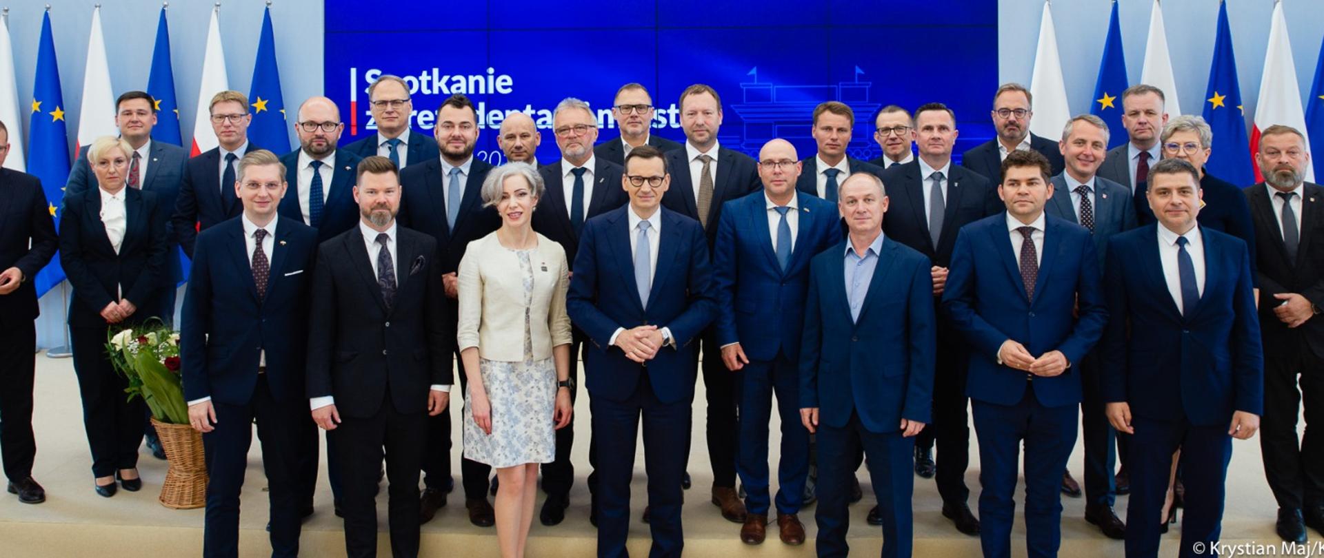 Premier Mateusz Morawiecki stoi wraz z prezydentami miast.