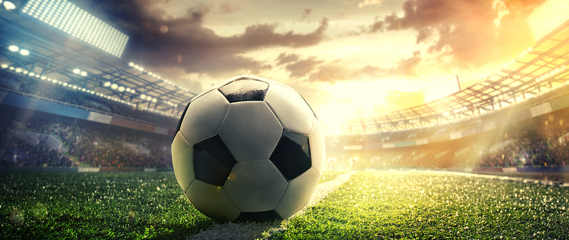 Piłka nożna na zbliżeniu. W tle widać trybuny stadionu.