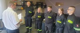 Zdjęcie przedstawia uczestników szkolenia podstawowego strażaków ratowników OSP wraz z Komendantem Powiatowym PSP w Obornikach oraz Dowódcą JRG Oborniki na tle budynku strażnicy. 