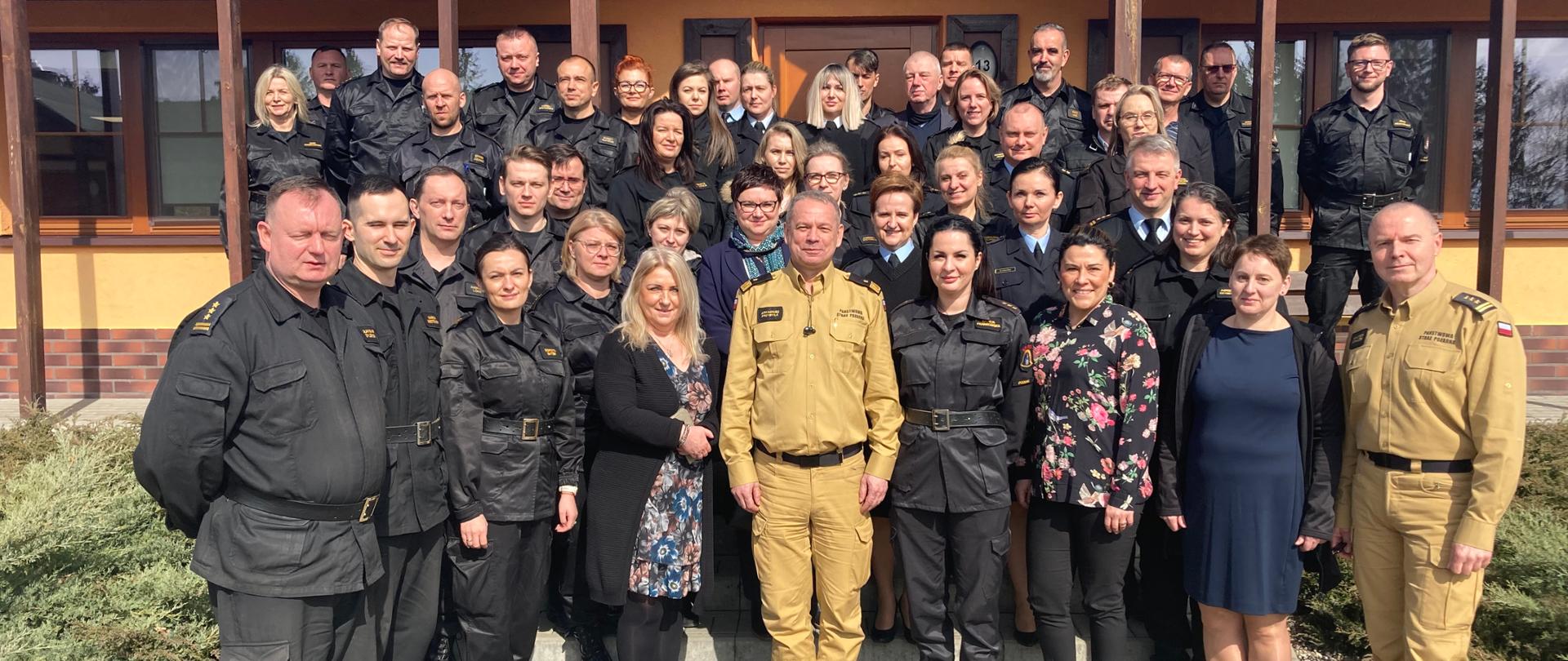 Zdjęcie grupowe - uczestnicy narady pozują do zdjęcia przed budynkiem