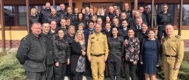 Zdjęcie grupowe - uczestnicy narady pozują do zdjęcia przed budynkiem