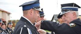 Druh Andrzej Bętkowski wręcza medale dwóm Druhom OSP