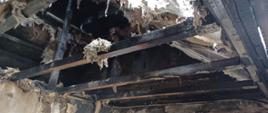 Zdjęcie przedstawia straty po pożarze. Nadpalona konstrukcja dachowa