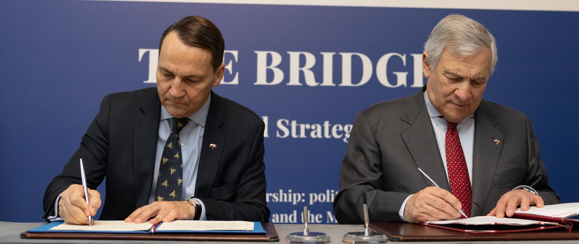 Deputy Prime Minister, Minister of Foreign Affairs of Poland Radosław Sikorski and Minister of Foreign Affairs and International Cooperation of Italy Antonio Tajani sit at a long table and sign documents