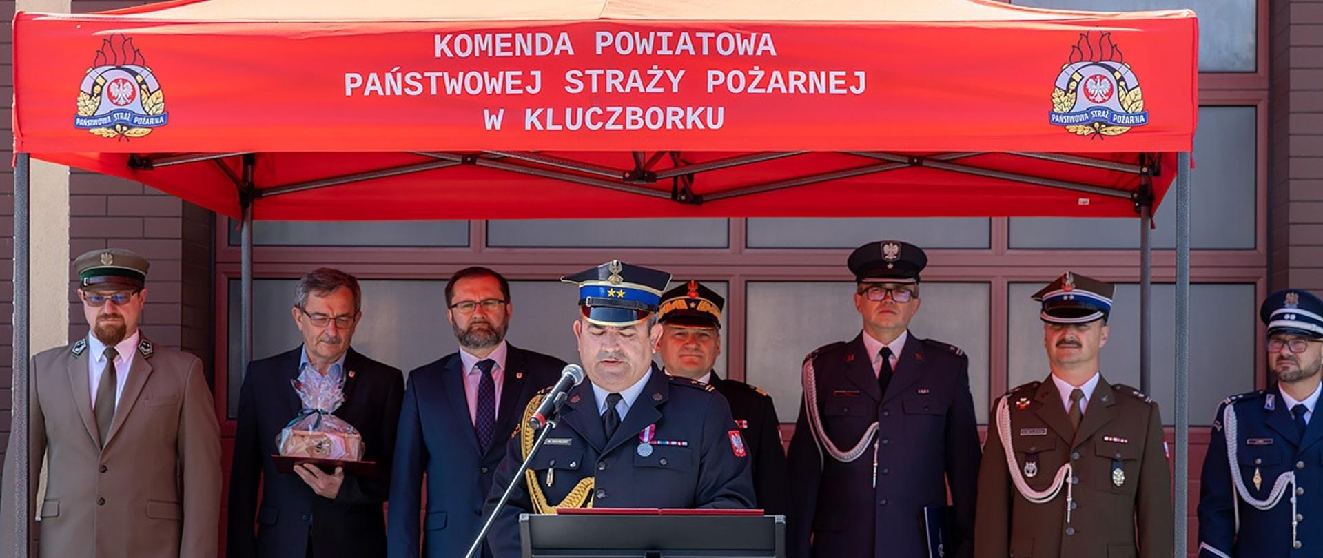 Komendant Powiatowy PSP w Kluczborku podczas przemówienia w trakcie uroczystej zbiórki 