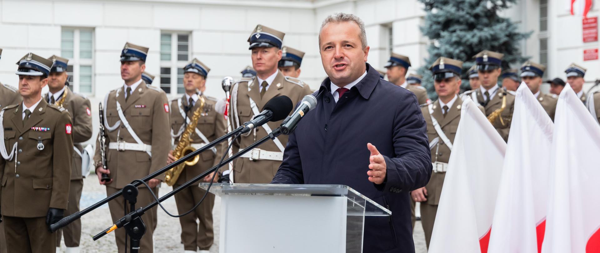 Jeden mężczyzna stojący przy mównicy i wypowiadający się 